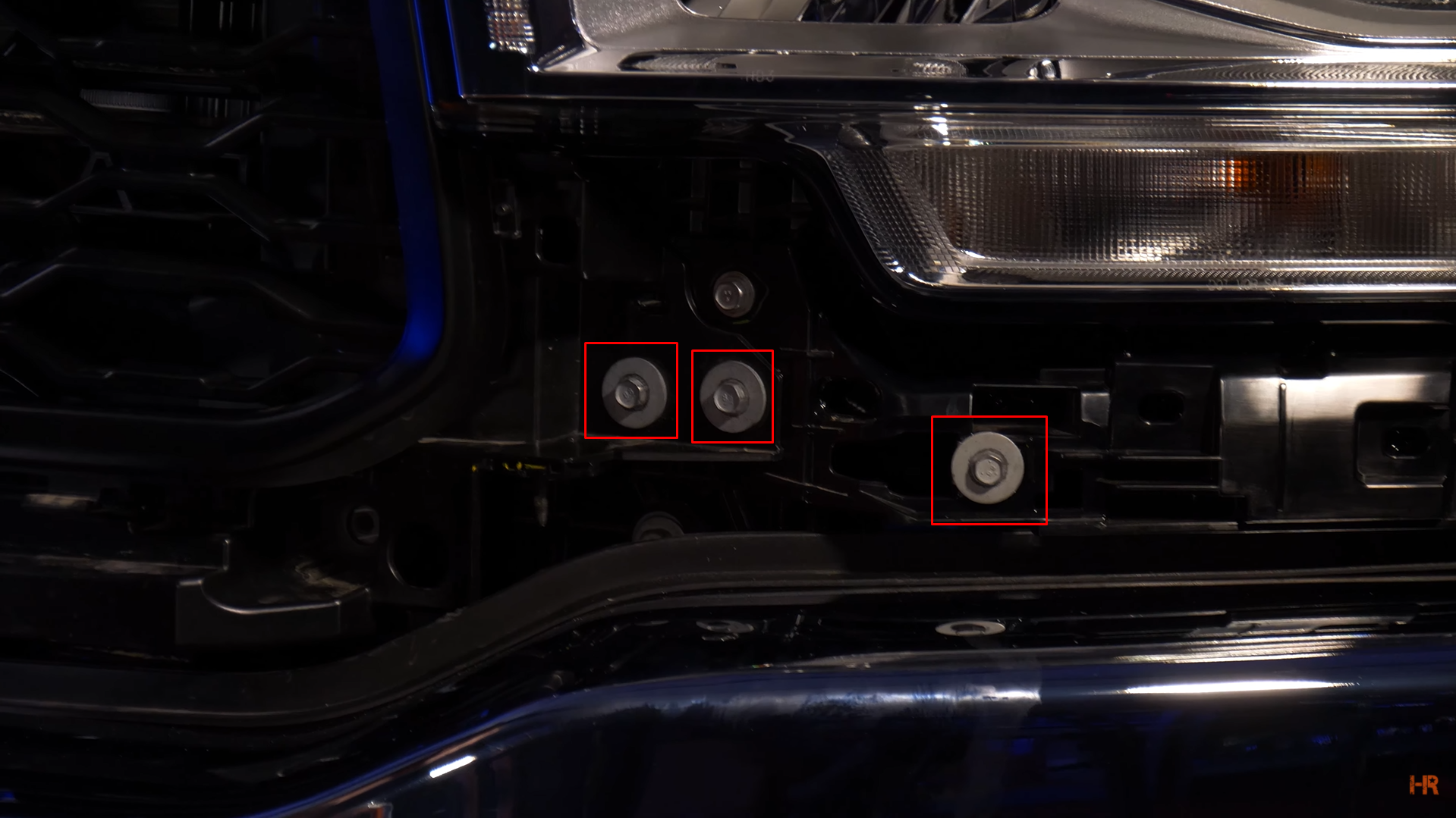 The location of three bolts holding in the grill.