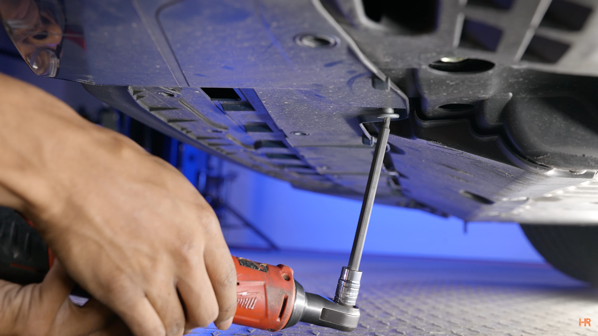 A man removes T10 screws from a Civic's base plate.