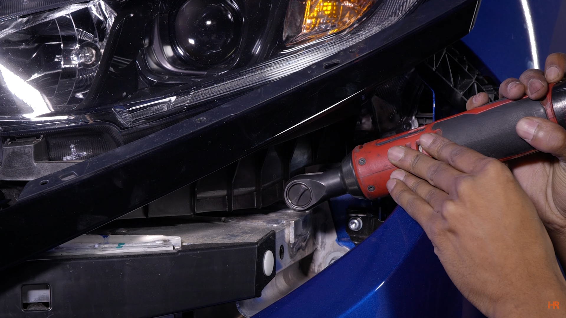 A 10mm bolt is removed from a Honda Civic headlight.