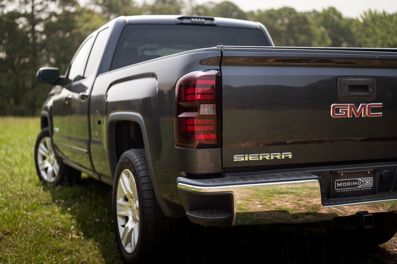 the-back-end-of-black-gmc-truck-parked-in-a-field